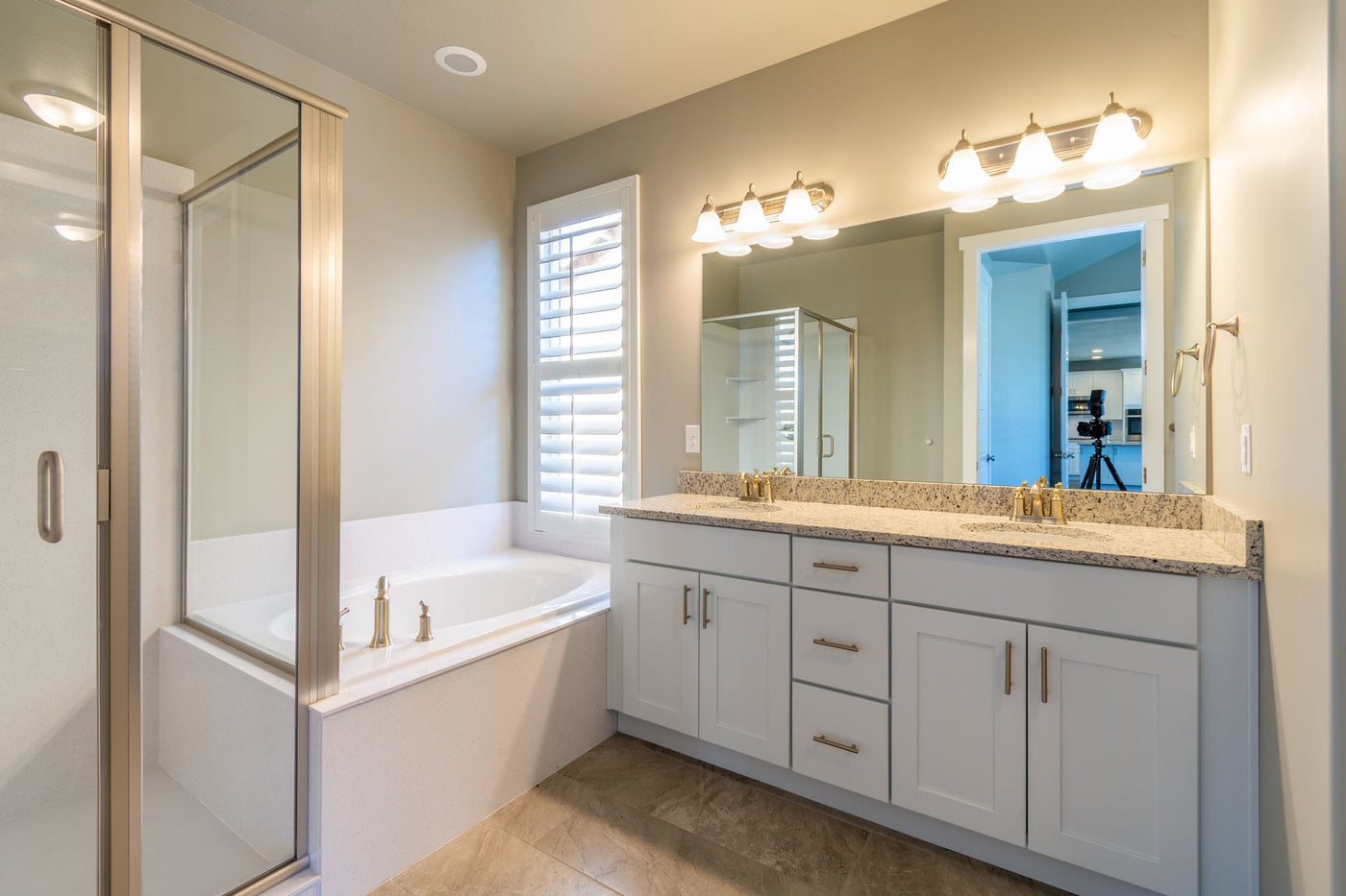 Bright modern bathroom featuring a shower, bathtub, and dual sink vanity.