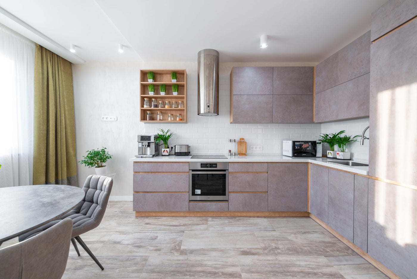 Interior of contemporary spacious kitchen zone with stylish furniture in apartment in sunlight