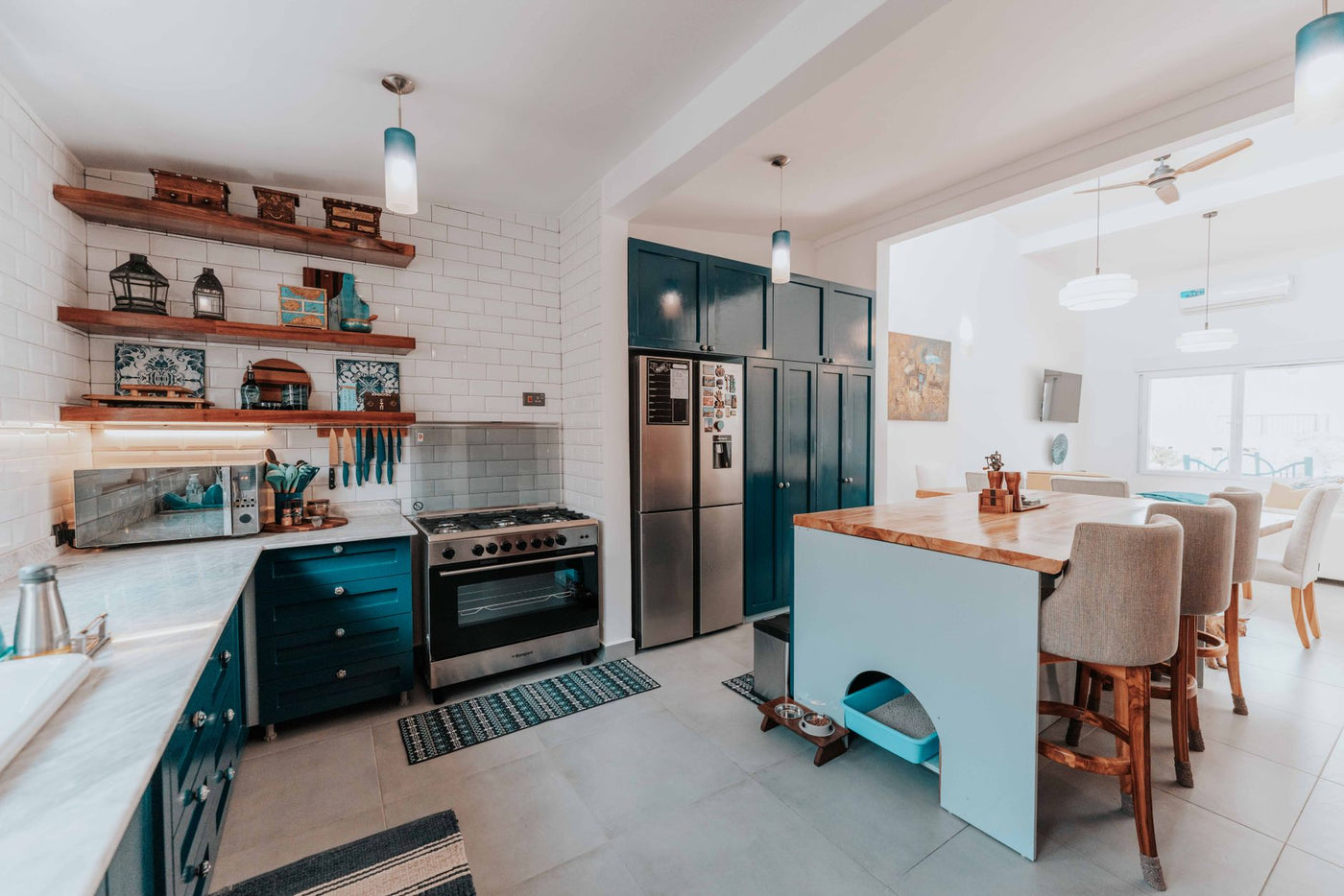 Spacious kitchen with blue cabinets, island, and modern appliances, highlighting a cozy dining setup.