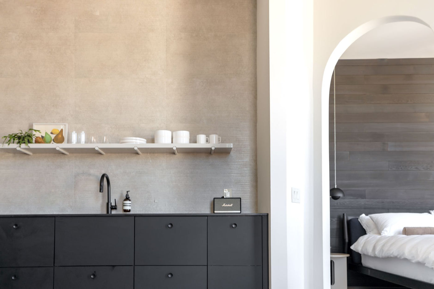 Sleek modern kitchen and bedroom archway in a Philadelphia apartment.